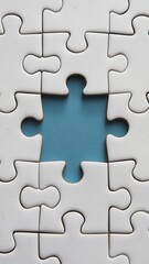 White jigsaw puzzle with one piece missing revealing blue background