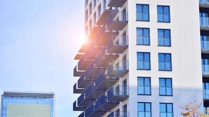 Modern high-rise apartment building  in white, stand tall against a blue sky, exemplifying...