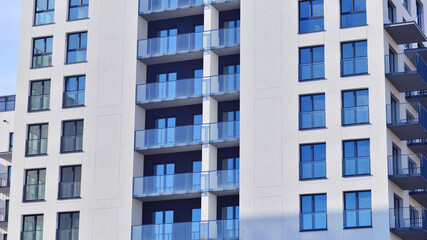 Modern high-rise apartment building  in white, stand tall against a blue sky, exemplifying...