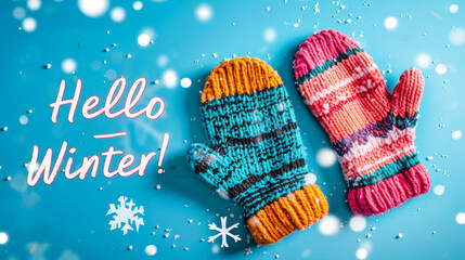 Knitted winter mittens with snowflakes and Hello Winter text on blue background
