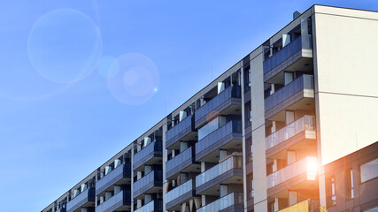 Modern high-rise apartment building  in white, stand tall against a blue sky, exemplifying...