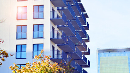 Modern high-rise apartment building  in white, stand tall against a blue sky, exemplifying...