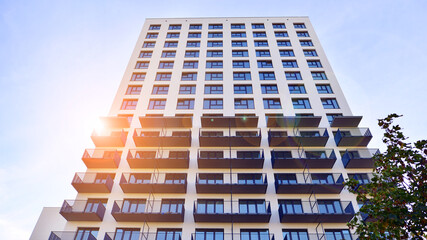 Modern high-rise apartment building  in white, stand tall against a blue sky, exemplifying...