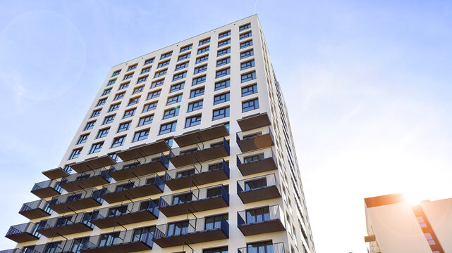 Modern high-rise apartment building  in white, stand tall against a blue sky, exemplifying innovative urban architecture with sleek, angular designs.