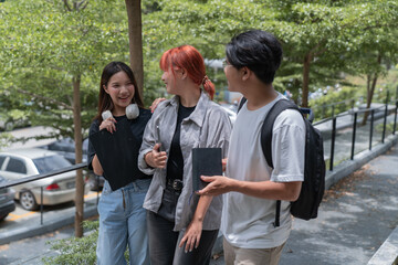 Fototapeta premium Three young students are walking and talking together on campus, enjoying their time between classes and sharing a moment of friendship
