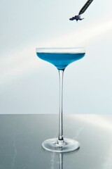 Blue Cocktail in a Tall Stem Glass with Flower Garnish