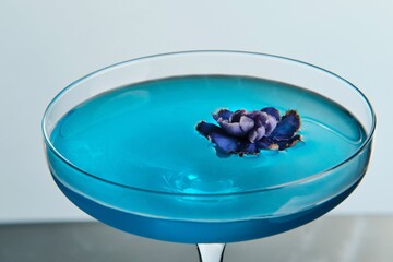Blue Cocktail in a Tall Stem Glass with Flower Garnish