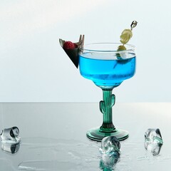 Blue Cocktail with Raspberry and Grape Garnish