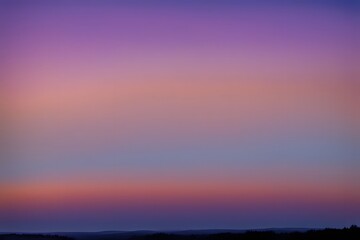 Obraz premium Clear evening sky with a warm orange horizon fading into deep blues and purples, AI Generated