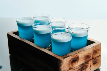 Blue Shot Cocktails with Foam and Floral Garnish