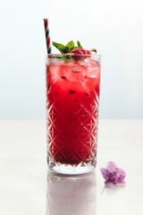 Vibrant Red Cocktail Garnished with Mint and Raspberries