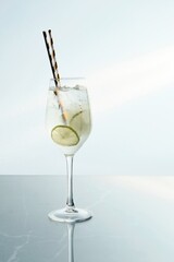 Elegant Clear Beverage with Lime and Pair of Straws