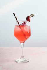 Red Cocktail with Ice, Berries, and Flower Garnish
