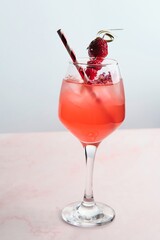 Red Cocktail with Ice, Berries, and Flower Garnish