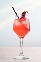 Red Cocktail with Ice, Berries, and Flower Garnish