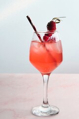 Red Cocktail with Ice, Berries, and Flower Garnish