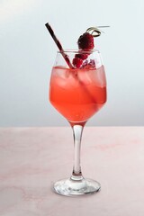 Red Cocktail with Ice, Berries, and Flower Garnish