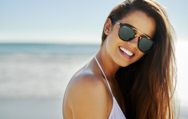 Woman, portrait and sunglasses on beach for holiday, vacation and summer adventure or ocean...