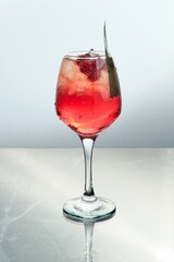 Hand Pressing Orange over Raspberry Red Cocktai