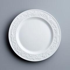 Elegant white plate with intricate floral design on a grey surface.