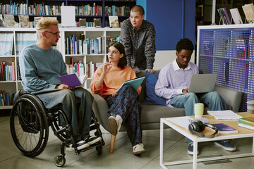 Group of diverse students collaborating in modern library environment discussing projects, sharing...