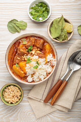 Aromatic massaman curry, a staple of thai cuisine, with tender beef, potatoes, and fluffy rice, garnished with peanuts and fresh herbs, a vibrant and flavorful dish of Thailand