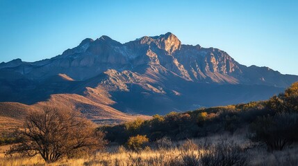 Obraz premium majestic mountain range rising dramatically against a clear blue sky, capturing the essence of natural grandeur and the awe-inspiring beauty of the wilderness
