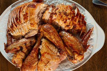 A top down view of a platter of roasted turkey pieces.