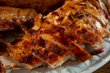 A view of a platter of roasted turkey pieces, featuring sliced breast.