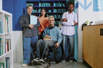 Group of diverse students standing in library with bookshelves background and wood counter highlighting study environment suited for teamwork and learning