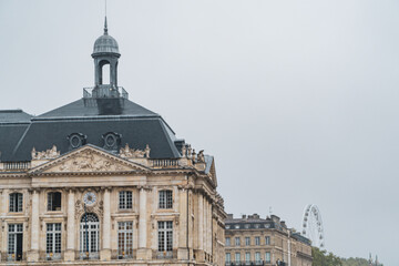 Classic buildings of Bordeaux downtown on Place de la Bourse square with ferris wheel on the background