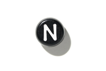 Round black button with white letter n on a white background.