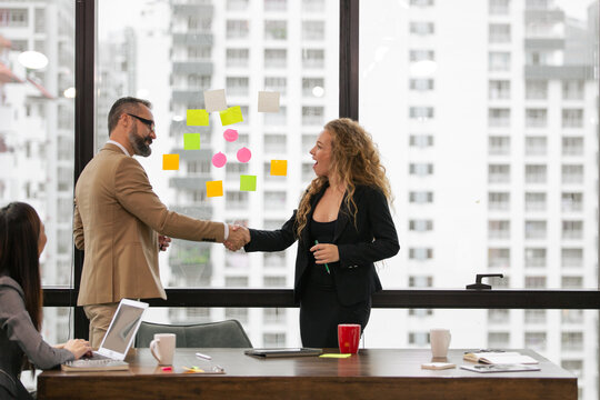 Male manager hand shaking with female partner to closing deal or success project in the modern office. Company project collboration concept