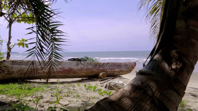 Traditional African dugout boat for fishing and travelling on a sandy beach. Natural wood texture on an authentic African boat.  Equatorial Guinea, Africa.