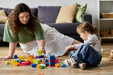 Naklejka premium A mother and daughter happily engage in creative play as they build with bright blocks together.