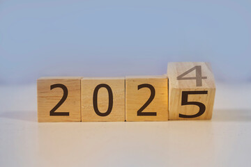 Goals moving forward to 2025, road to next, numbers on wooden box on blue background.,Entering 2025