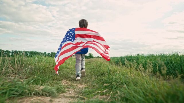 Cute little boy - American patriot kid running with national flag on open area countryside road.USA, 4th of July - Independence day, celebration. US banner, memorial Veterans, election