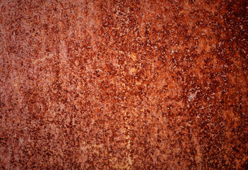 Backdrop of rusty surface of dark, brown, and orange hues. Detailed grunge rusted metal texture. Close-up of rust patterns, aged iron, scratched, worn, distressed areas, decay, corrosion details