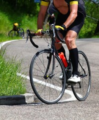Naklejka premium cyclist struggles up a steep hill on a racing bike during a hot summer day