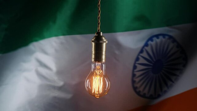 Glowing Edison light bulb on Indian flag background. Electricity price, bills, energy crisis, raising tariffs.
