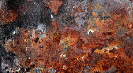 Backdrop of rusty surface of dark, brown, and orange hues. Detailed grunge rusted metal texture. Close-up of rust patterns, aged iron, scratched, worn, distressed areas, decay, corrosion details