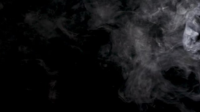 White smoke texture isolated on dark background. White mysterious smoke on black background