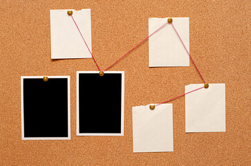 Blank paper notes and an empty photo are pinned to a cork board. The concept of detective investigation.