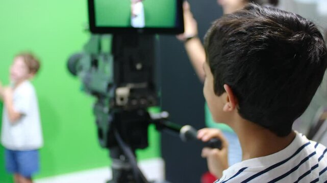 oy learns to use video camera. Filmmaking, education, technology, green screen, studio, learning, childhood.