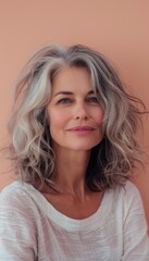 Fototapeta premium Portrait of a Thoughtful Middle-Aged Woman on a Pastel Peach Background for Inner Peace Concepts