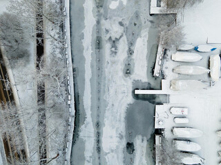 Aerial top down of boats and frozen Söderström river during winter in Stockholm