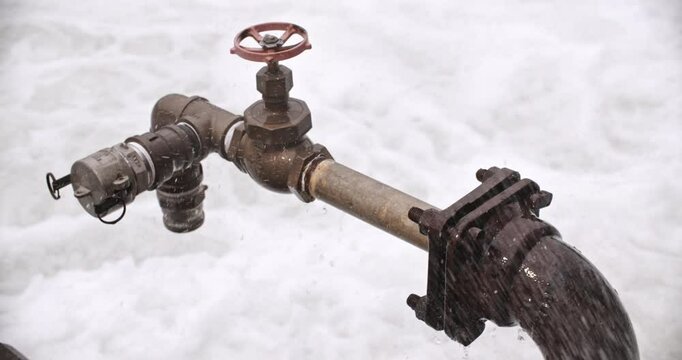 Medium shot on pipe fixtures and joints surrounded by splashing and sloshing water, with audio.