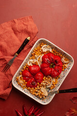 Delicious vegan plate of roasted bell pepper and chickpeas on vibrant red background
