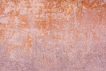 Textured surface with shades of pink, orange, and brown, appearing weathered.