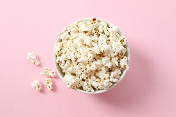 Delicious popcorn in a bowl on a color background